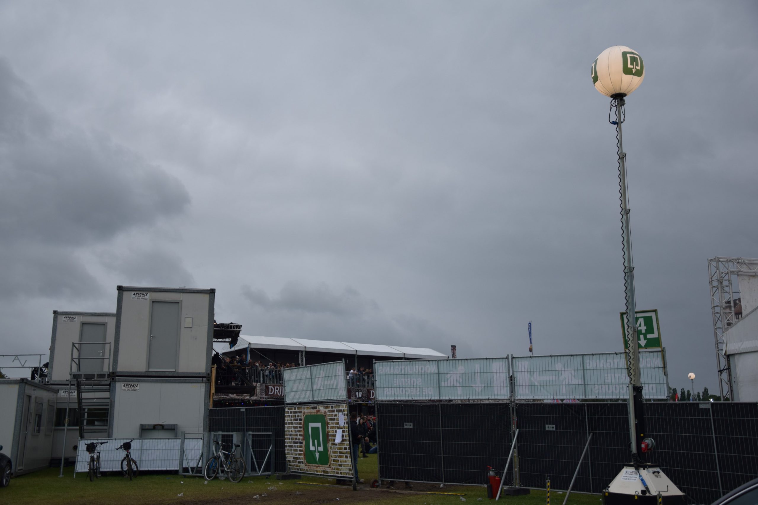 Mâts avec ballon et pictogramme personnalisable, en arrière plan des héras avec bâches personnalisées